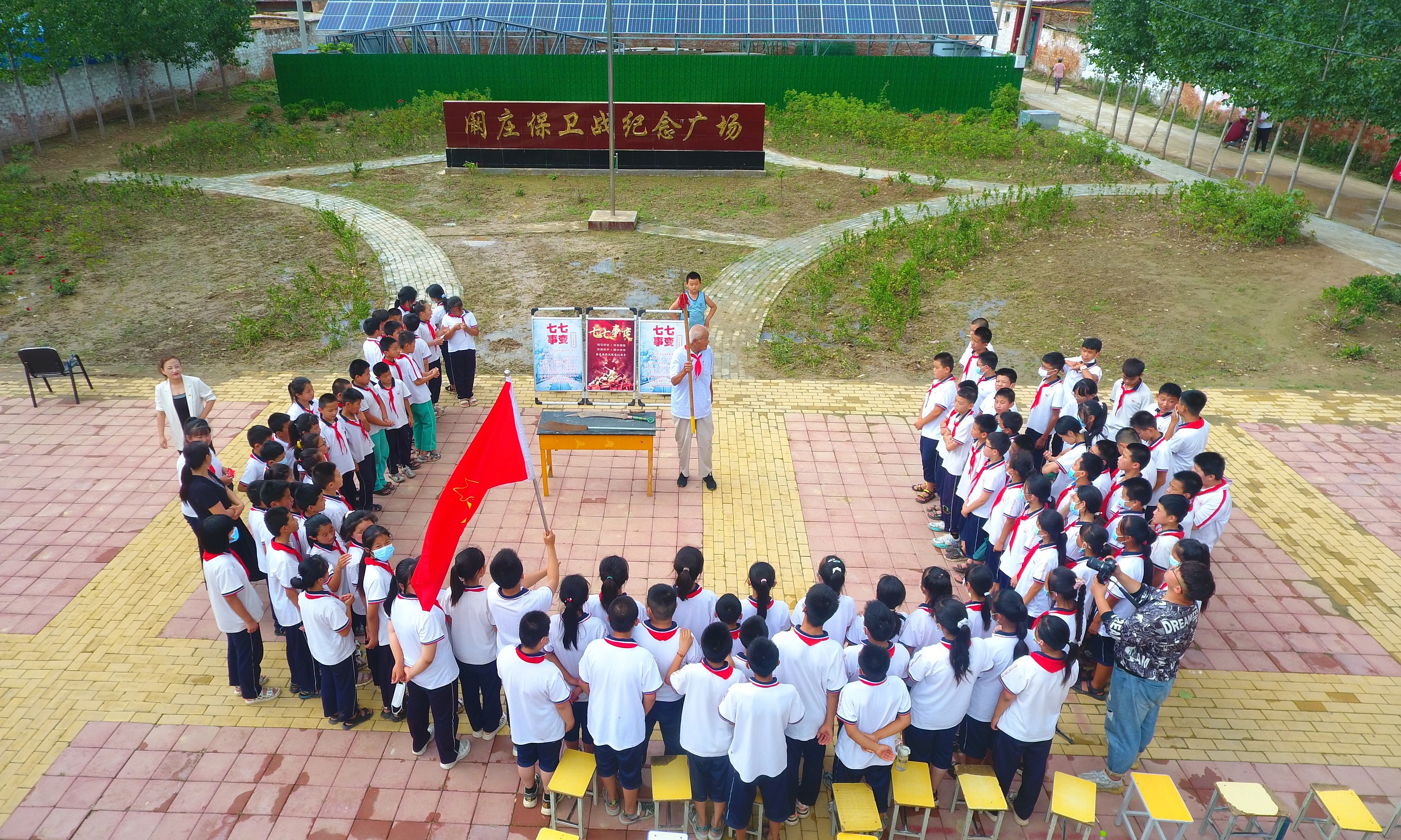 2022年7月6日，山東省聊城市，在茌平區(qū)菜屯鎮(zhèn)闞莊村的闞莊保衛(wèi)戰(zhàn)紀(jì)念廣場，闞莊保衛(wèi)戰(zhàn)親歷者王光木老人，為小學(xué)生們講述抗戰(zhàn)故事，展示大刀、長矛。