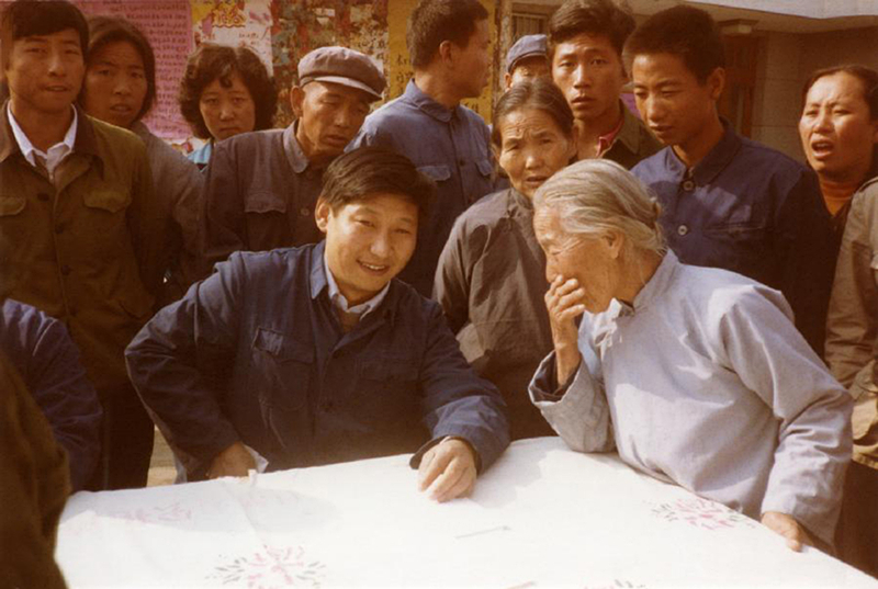 1983年，時(shí)任河北正定縣委書記的習(xí)近平（前排居中），臨時(shí)在大街上擺桌子聽取老百姓意見。